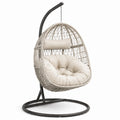 Fauteuil suspendu en rotin synthétique beige avec coussins et structure en acier